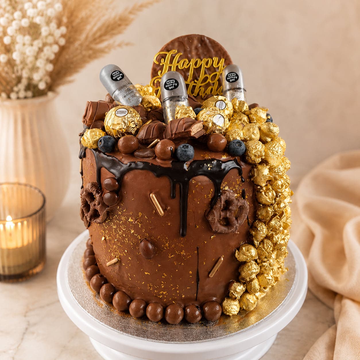 Chocoladetaart met een donkere drip, Ferrero Rocher, Maltesers en goudkleurige popcorn