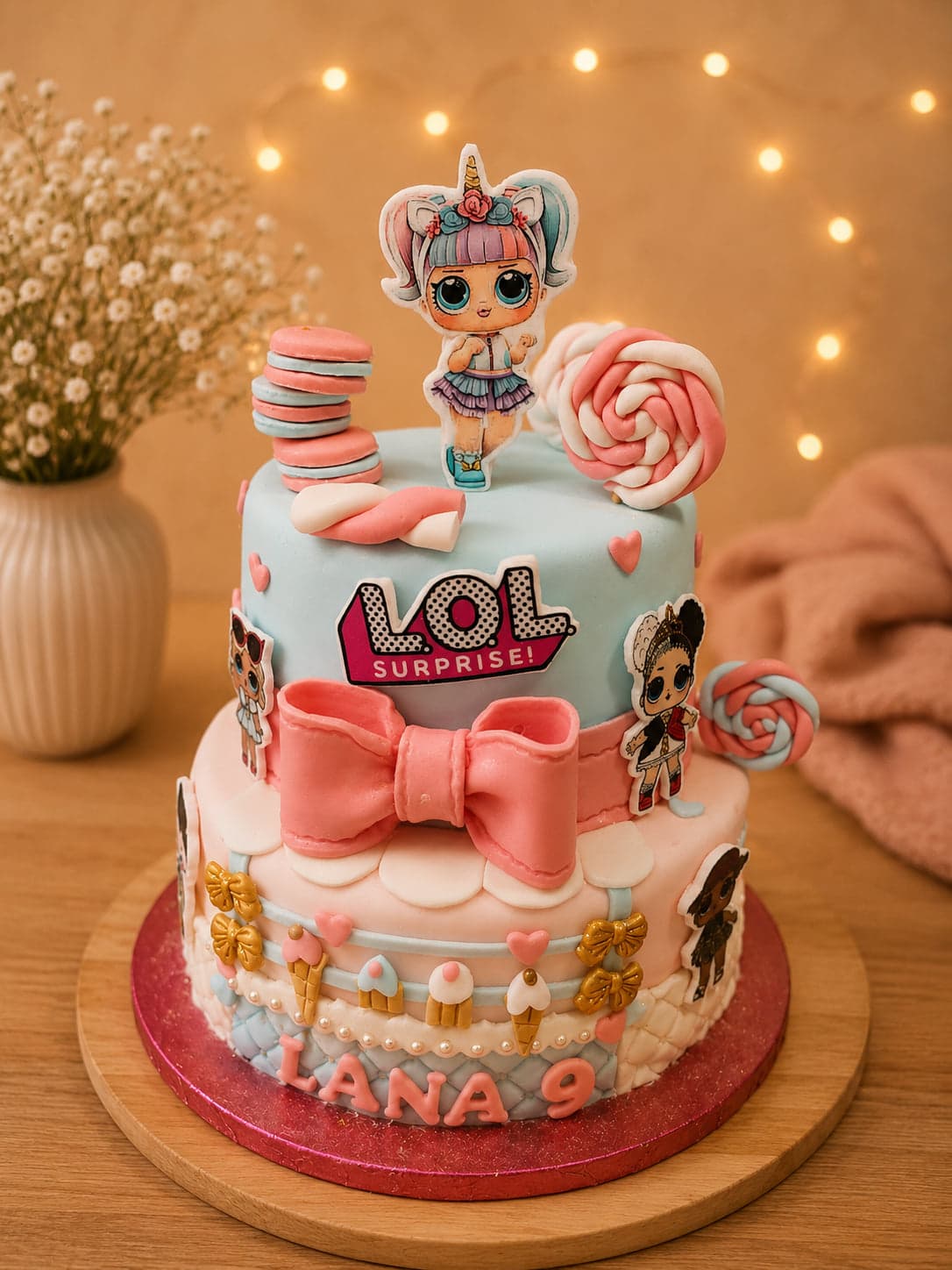 Themataart van twee lagen met L.O.L. Surprise-poppetjes, een roze strik en lolly's, met de naam Lana